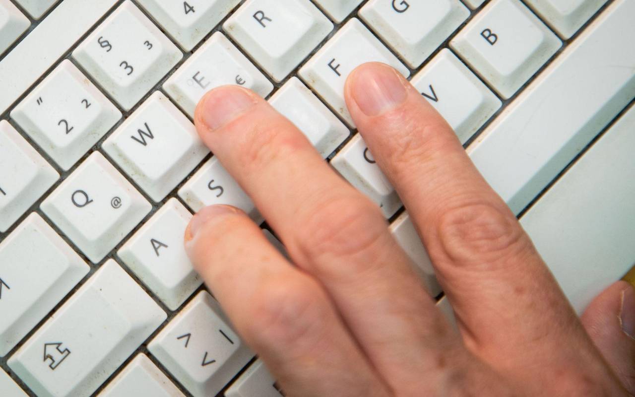 Mann tippt auf einer Tastatur