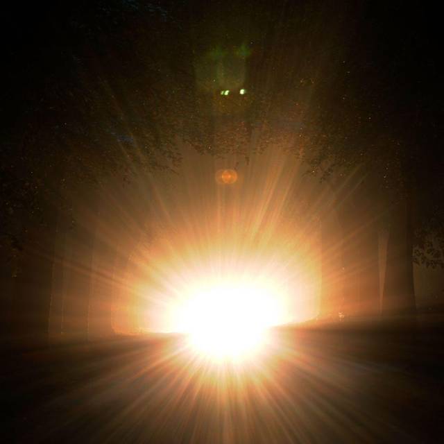 Auto mit Aufblendlicht bei Nacht