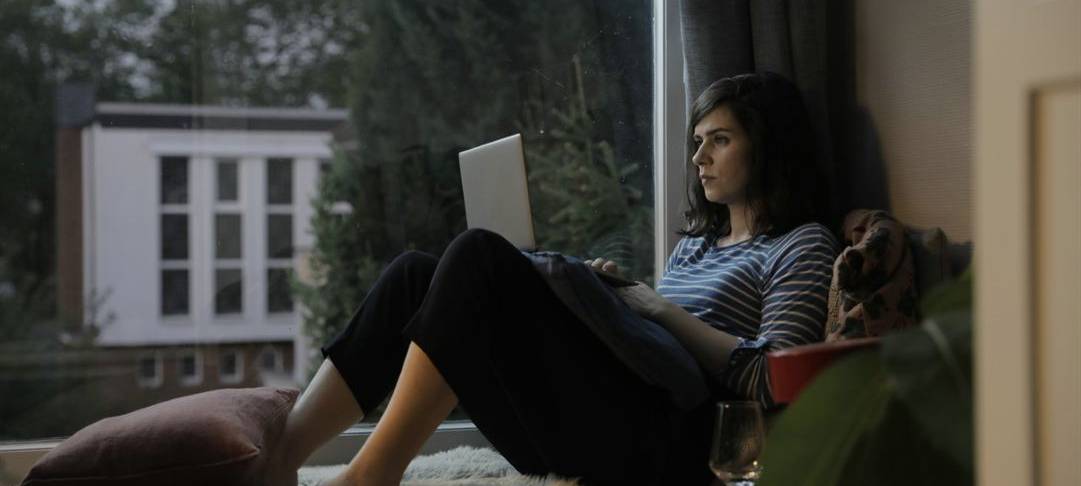 Emma checkt ihre Mail auf der Fensterbank.