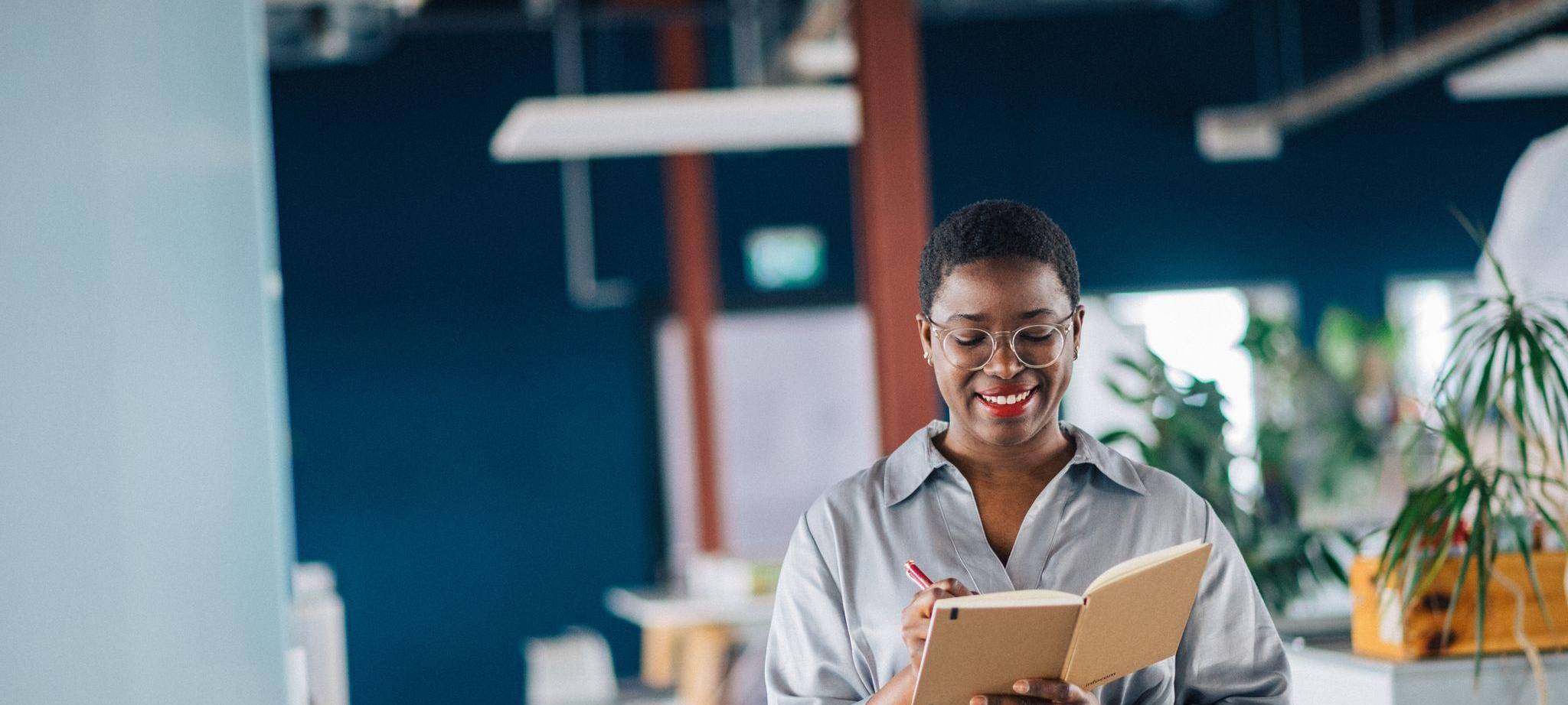 Eine junge Frau schreibt in ein Notizheft