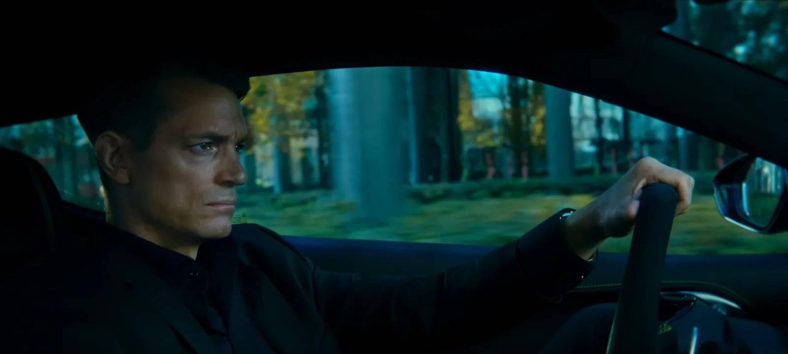 Harrys Kollege Tom am Steuer seines für einen Beamten viel zu teuren Autos.